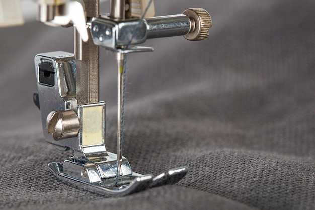 Sewing machine stitching fabrics needle in a round plan close up