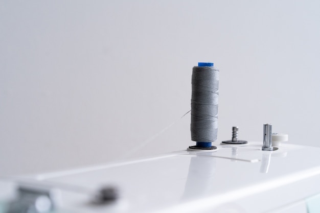 Sewing machine with a gray spool of sewing thread