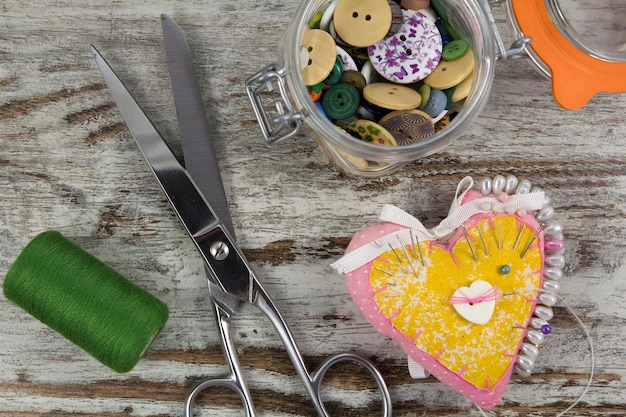 Sewing tools in a wooden background