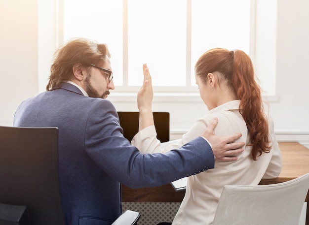 Sexual harassment at work, lustful boss touching young woman in office, back view, copy space