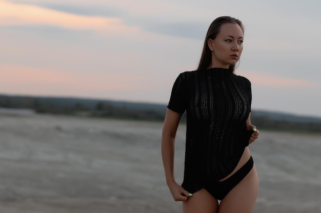 Sexual woman in black outfit on beach