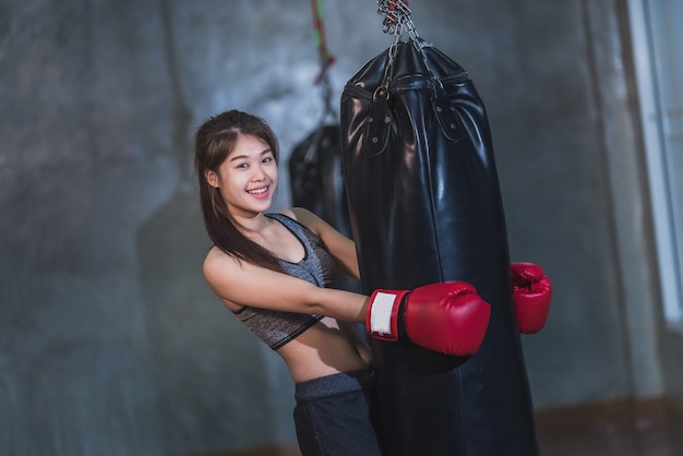 Sexy asia girl punching boxing bag