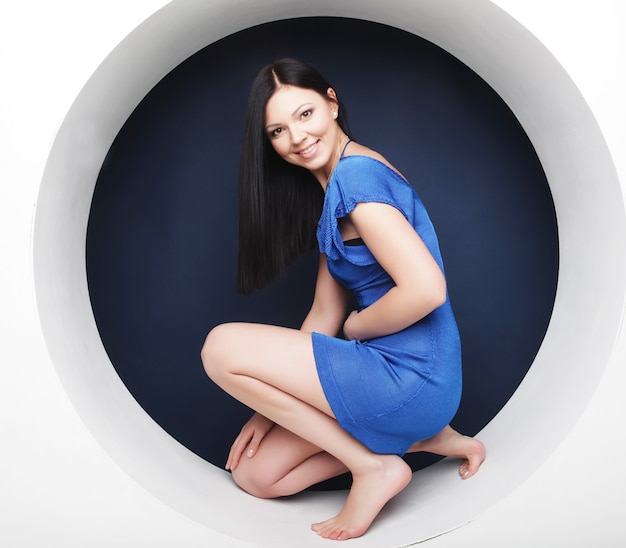 Sexy brunette in blue dress sitting in a circle