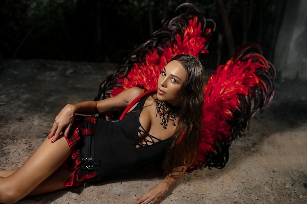 Sexy devil concept. Demon sexy girl with long hair. Girl sexy demon with wings, devil full of desire. Woman on passionate face play role game. Lady sexy dressed as demon, devil, black background