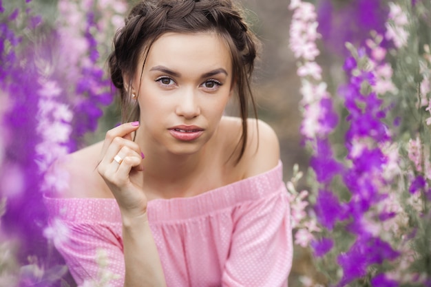 Sexy elegant woman on the meadow of flowers. Beautiful female outdoors. Freedom concept