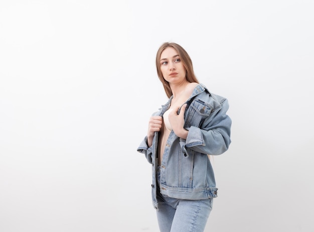 Sexy fashionable vogue woman model dressed in jeans and denim jacket on white background