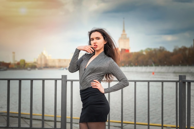 Sexy girl in a black skirt on the pier