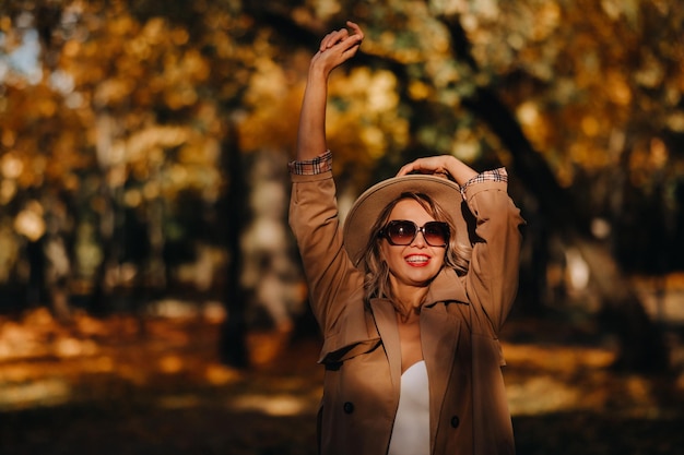 Sexy girl in a coat and hat in an autumn sunny park