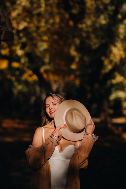 Sexy girl in a coat and hat in an autumn sunny park