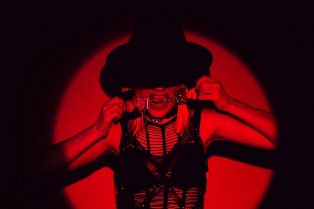 Sexy girl in underwear and hat holds handcuffs in teeth BDSM concept of a submissive woman