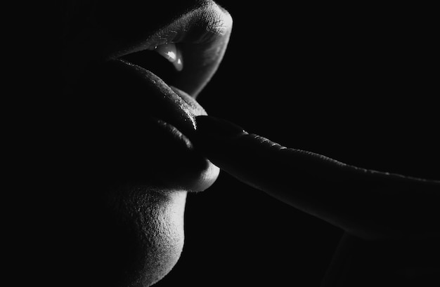 Photo sexy lips lick finger closeup on black suck and oral concept woman lips tongue sweet dreams female mouth licks