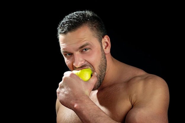 Sexy man eat apple. Close up guy face.