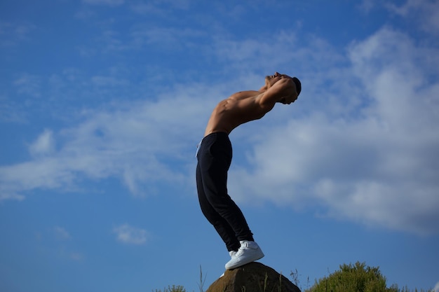 Sexy muscular man on sky background