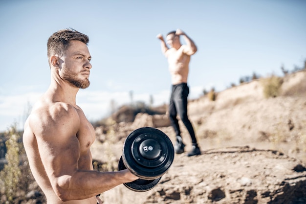 Sexy portrait of muscular handsome topless male model Shirtless strong man training outdoor