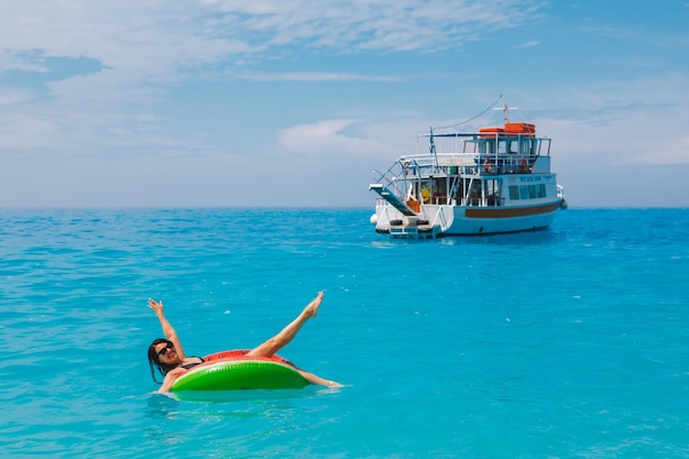 Sexy woman swimming in blue sea on inflatable ring