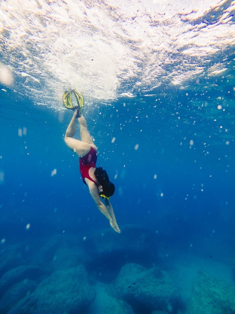 Sexy woman swimming underwater in diving mask with flippers summer vacation