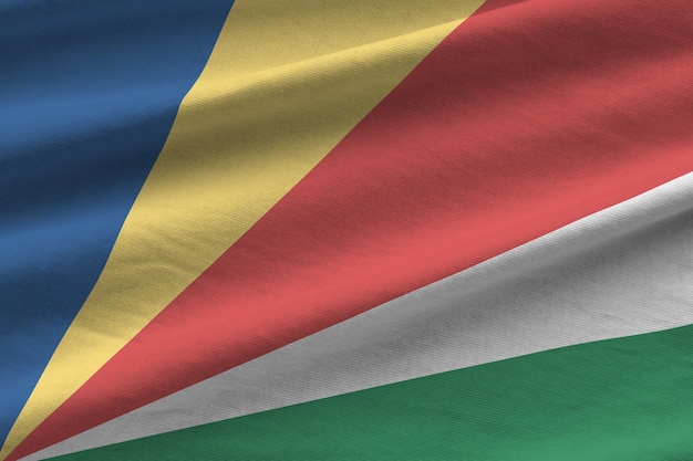 Seychelles flag with big folds waving close up under the studio light indoors the official symbols a