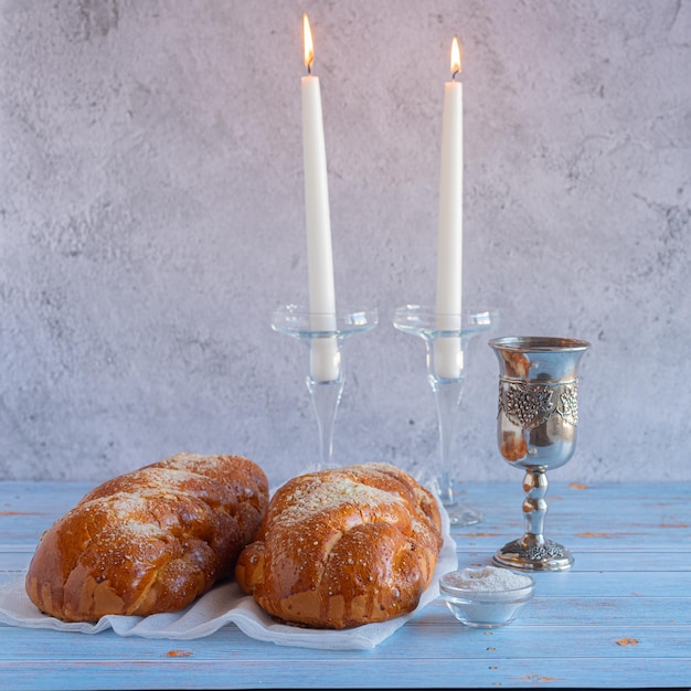 Photo shabbat shalom challah bread shabbat wine and candles on wooden table