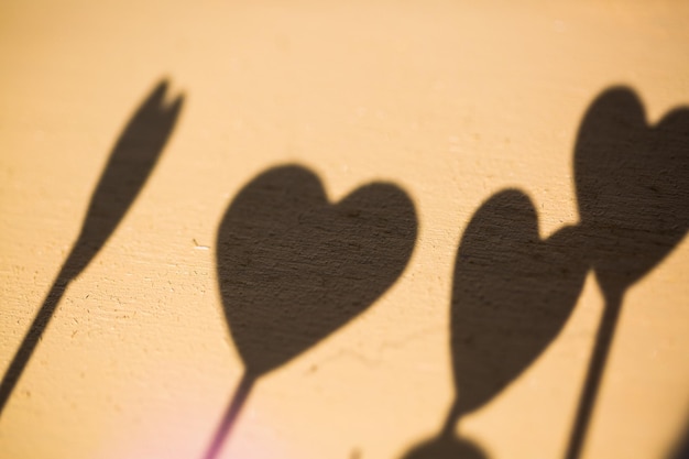 Photo shadows of heart shapes on brown wall