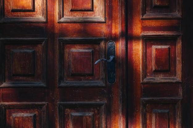 Shadows and light on an old wooden front door Background texture or wallpaper