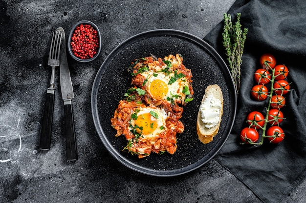 Shakshuka in a dark plate with fresh ingredients