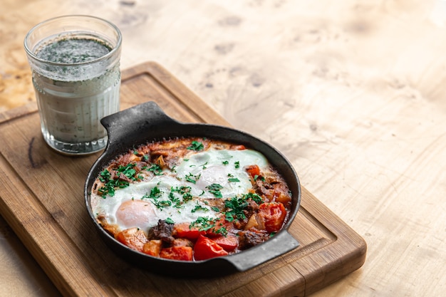 Shakshuka in a frying pan and a glass of ayran healthy and tasty food