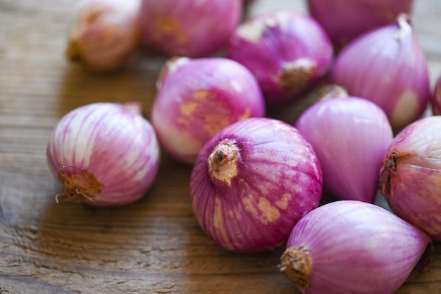 Shallots or red onion purple shallots on wooden background fresh shallot for medicinal products or herbs and spices Thai food made from this raw shallot