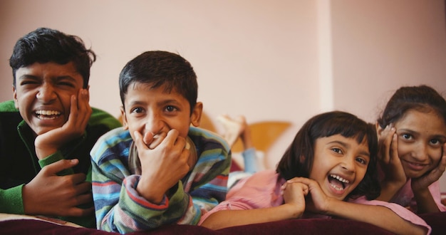 Shallow focus of four siblings enjoying a funny show on the television