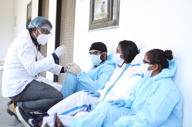 Shallow focus shot of Indian healthcare workers in protective clothing talking outdoors