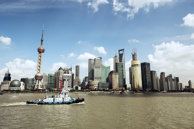 Shanghai skyline at daytime and a tugboat on the huangpu river