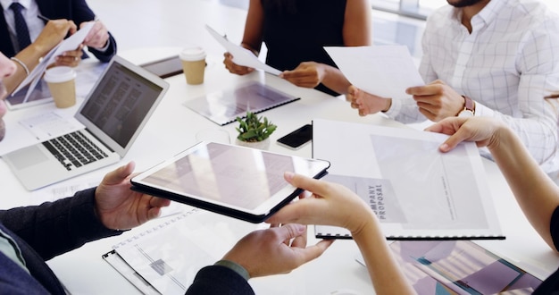 Sharing information with the team Cropped shot of a group of businesspeople sitting around the boardroom table during a meeting