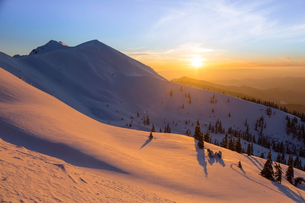 The sharp peaks of the winter mountains under sunset sky