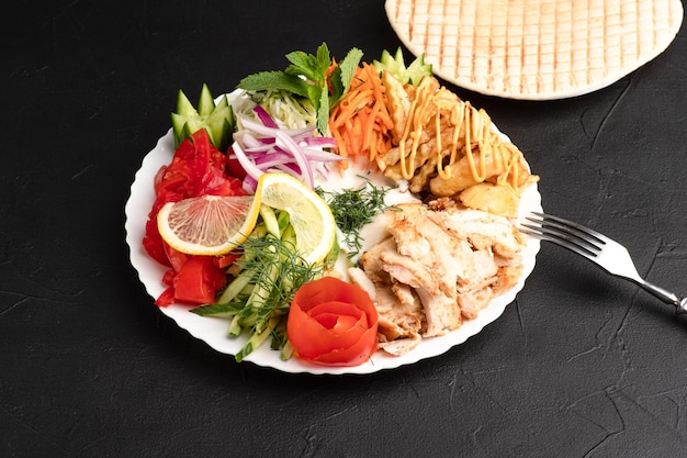 Shawarma on a plate a large portion of shawarma on a plate side view black background