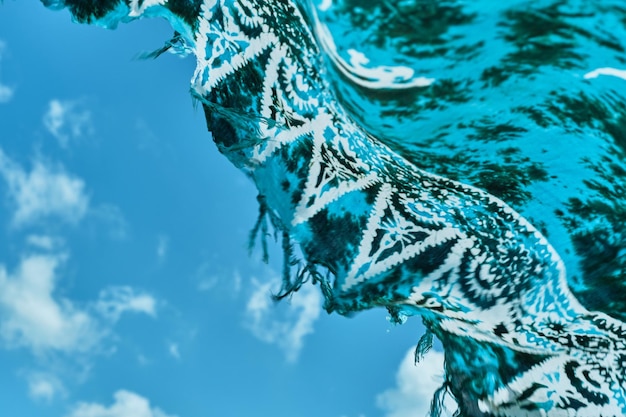 Shawl gracefully develops against the sky Sea breeze on the coast pareo closeup blurry not sharp abstract background sea holiday idea