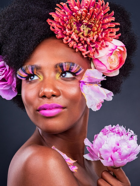 She has flowers in her hair and magic in her eyes Studio shot of a beautiful young woman posing with flowers in her hair