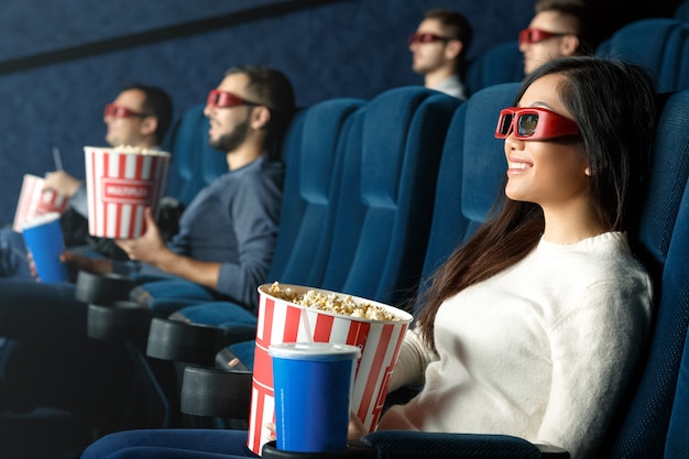 She loves 3d movies. Cheerful young woman laughing watching 3d movies wearing glasses