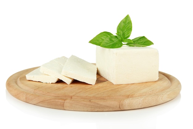 Sheep milk cheese with basil on cutting board isolated on white