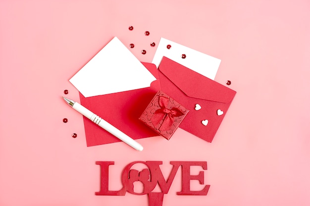 sheet of paper for message, red envelope, gift box, tittle sparkles, pen  Happy valentines day 