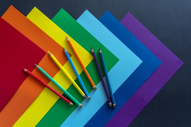 Sheets of multi-colored paper with colored pencils . Colors of rainbow. LGBT community symbol