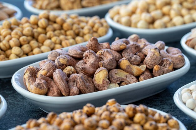 Shell cashew in selective focus Nuts on plate on a dark background Walnut Chickpeas White Chickpeas Dry mulberry almond cashew pistachio Types of nuts on the plate