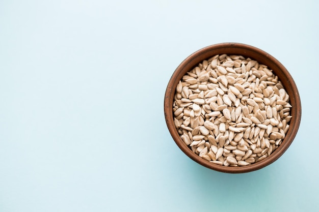 Shelled sunflower seeds over blue background