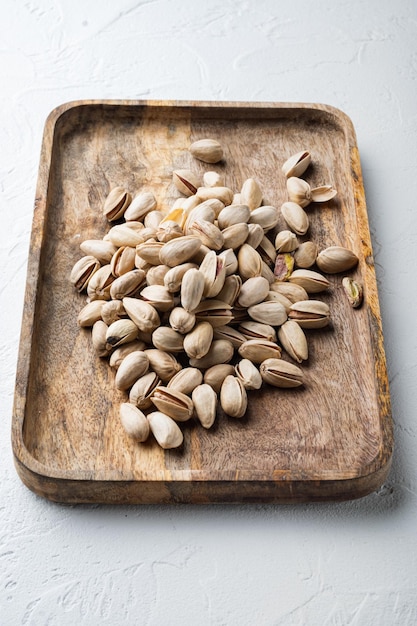 Shelled unsalted pistachios on white textured background