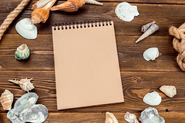 Shells and notepad on wooden table. 