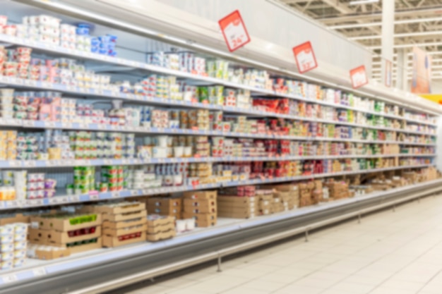 Shelves with products in a big supermarket. Blurred.