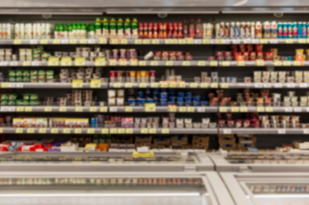 Shelves with a variety of dairy products in the supermarket. Blurred. Front view.