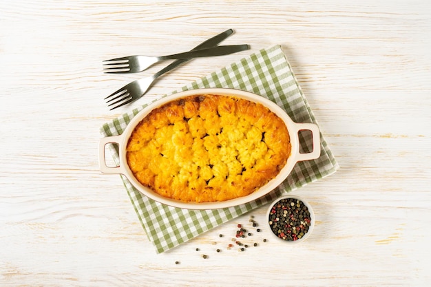 Shepherd's Pie or Cottage Pie traditional British dish on white wooden background