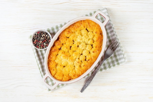 Shepherd's Pie or Cottage Pie traditional British dish on white wooden background