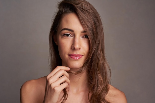 Shes got that innocent yet mesmerising beauty Studio portrait of an attractive young woman posing against a dark background