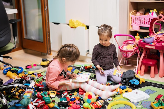 Shildren have made a toy mess in the children's room and are playing with toys