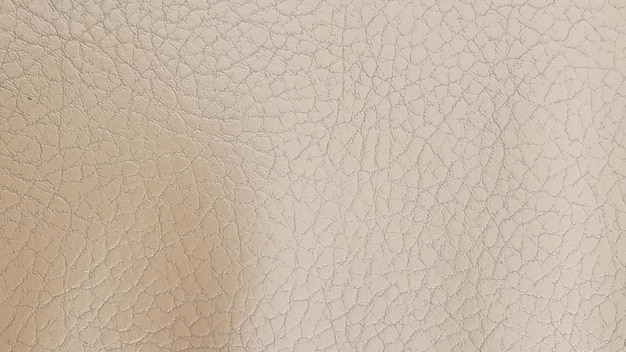 Photo shiny beige leather background closeup beige glossy texture of artificial leather